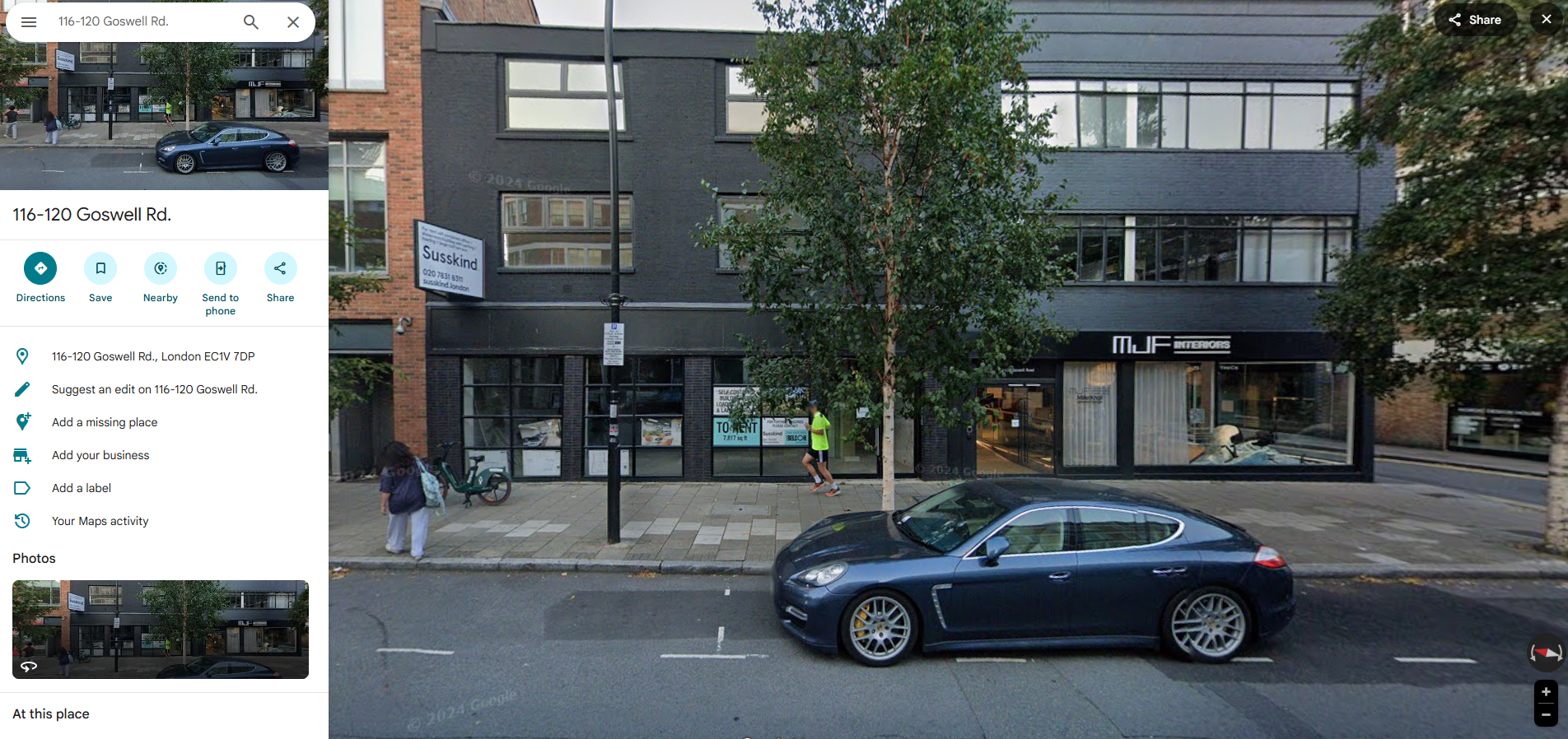 Street View of 116–120 Goswell Road showing the black-bricked office building, street trees, and shopfronts including MJF Interiors.